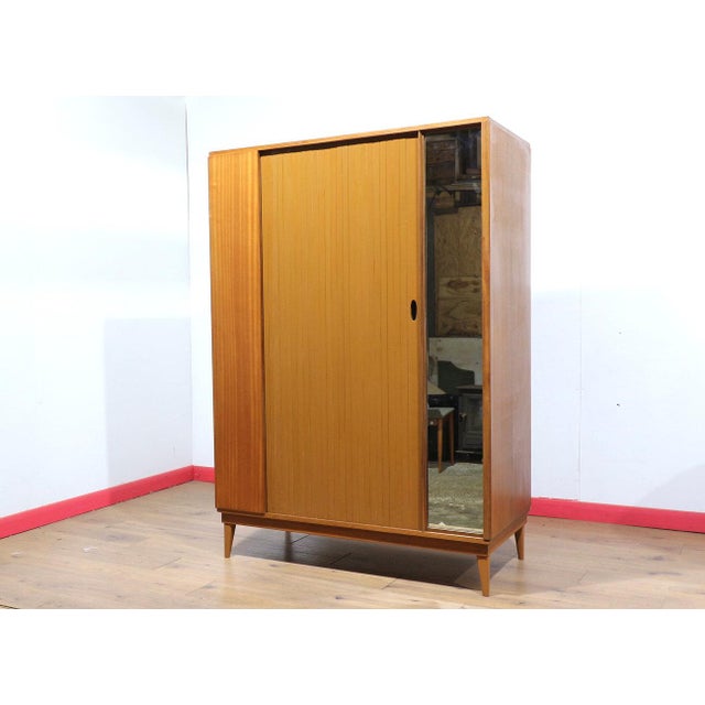 A classic mid century wardrobe by renowned British furniture maker Austinsuite, this vintage teak armoire combines...