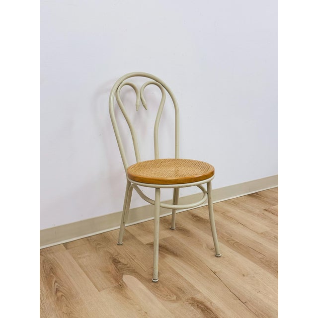This charming vintage white metal bentwood style chair with caned seat is a clean and versatile accent seating find. The...