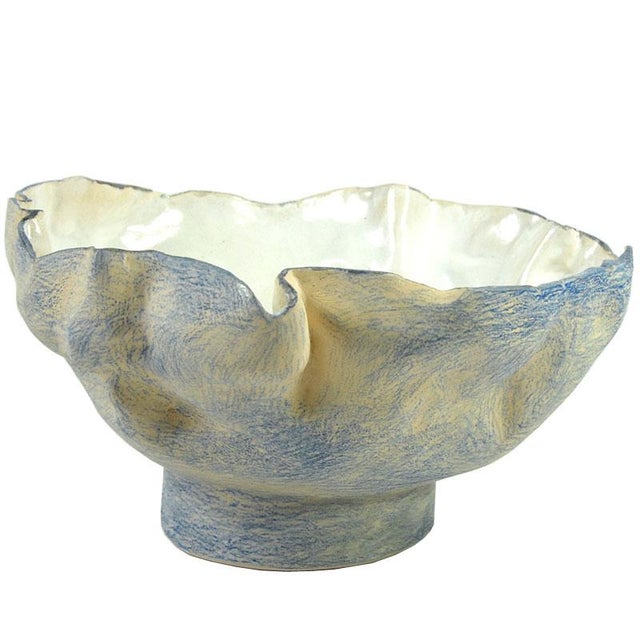 A large, sculptural bowl made of ceramic, decorated with underglaze crayon and glazed. The glaze inside the bowl is quite...
