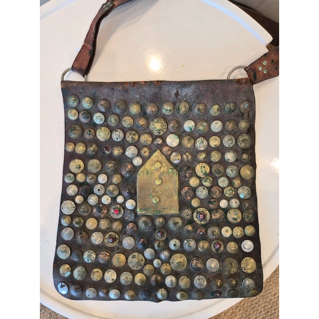 An antique Moroccan water seller leather bag. It is studded in many different coins. This is a traditional bag that was...