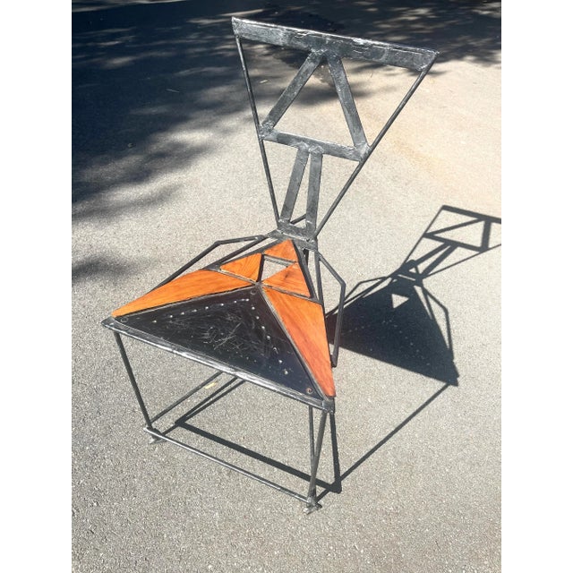 Handmade postmodern iron and wood triangular chair. Great as an accent chair or piece of art on which to display things.