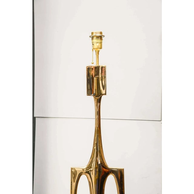This sculptural floor lamp in polished bronze was designed Robert Phandeve. Up to 250V (Europe/UK Standard).The wiring of...
