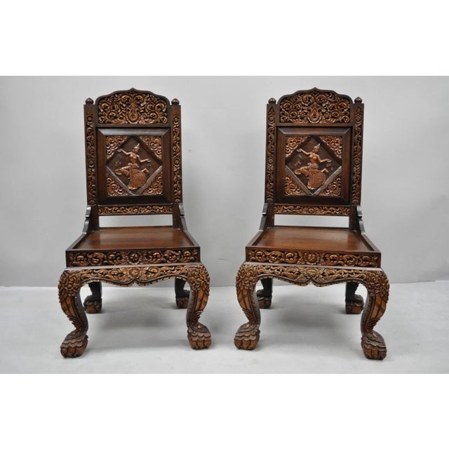 Vintage Chinoiserie Thai Oriental Carved Teak Wood Dining Side Chairs - a Pair. Item featured is ornately carved...