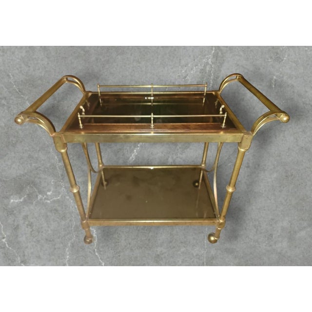 Beautiful 2 tiered vintage serving cart features a removable burl and smoked glass tray on the top with brass handles for...