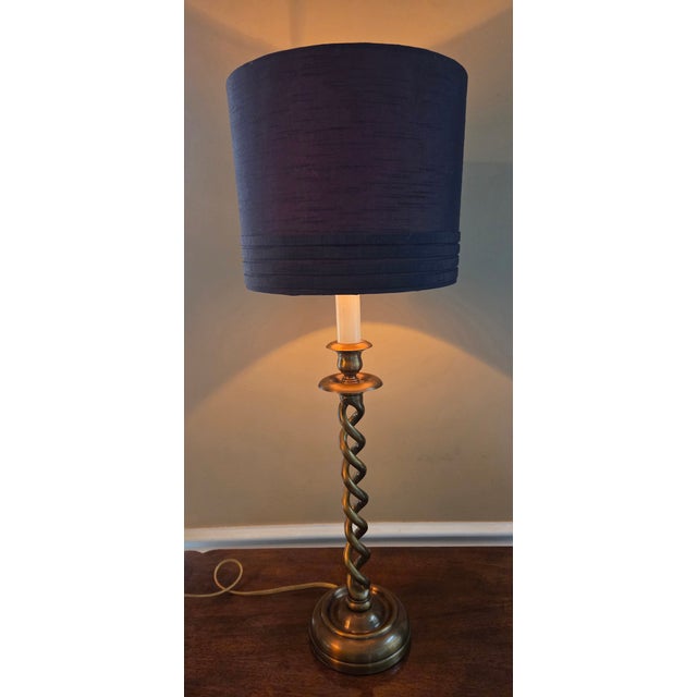 Antique brass finish open barley twist candlestick lamp with shade. The electric cord runs up through one of the twists....
