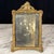 Elegant antique French gilt metal tabletop photo frame with a finely cast Rococo-inspired design featuring scrolling...