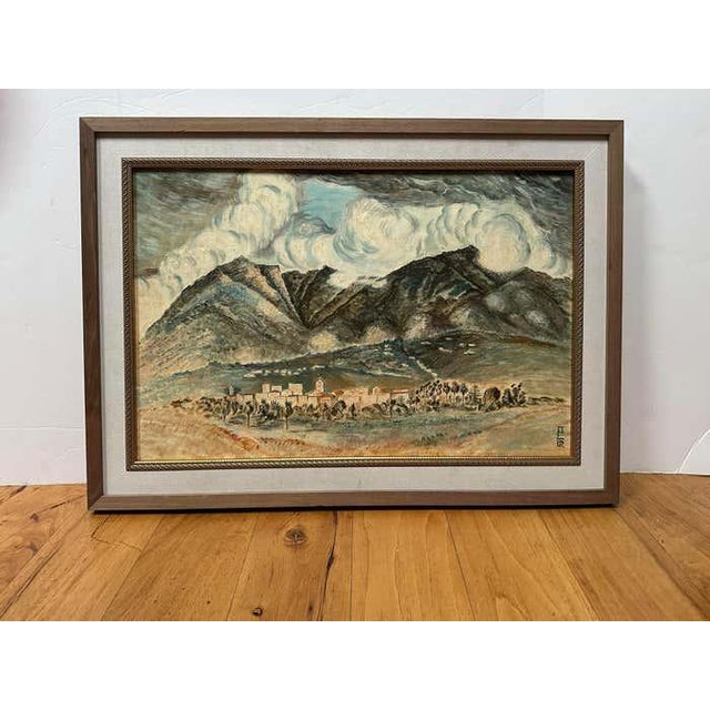 This Mid-Century oil painting depicts, mountains, voluminous clouds and a small village. The mountains and clouds have a...