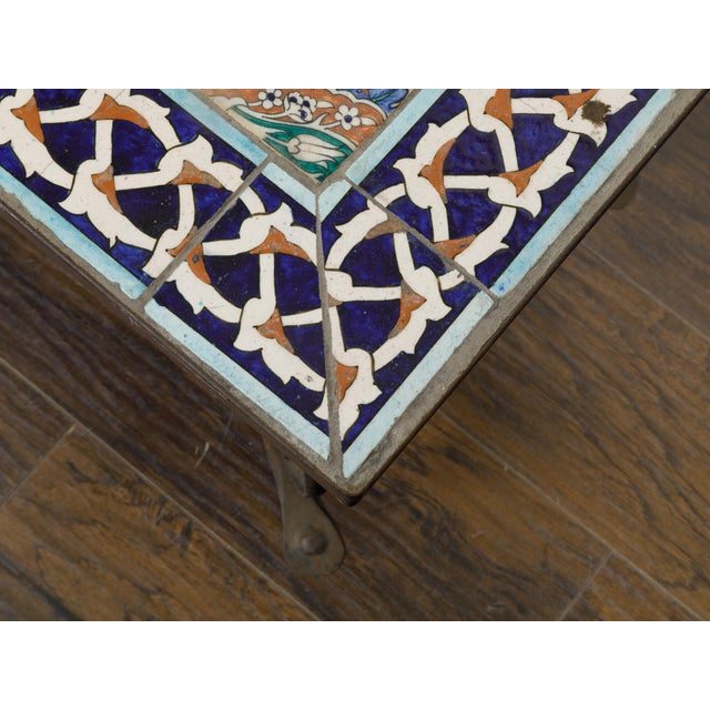 An Italian wrought-iron coffee table from the Midcentury period, with tile top and scrolling base. This Italian Midcentury...