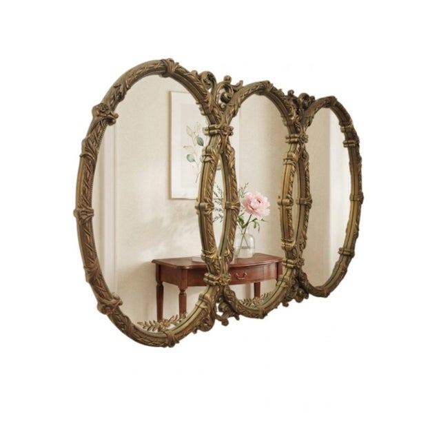 A beautiful very elegant vintage Hollywood regency very large triple oval ornate wall mirror. The mirror has a pretty...