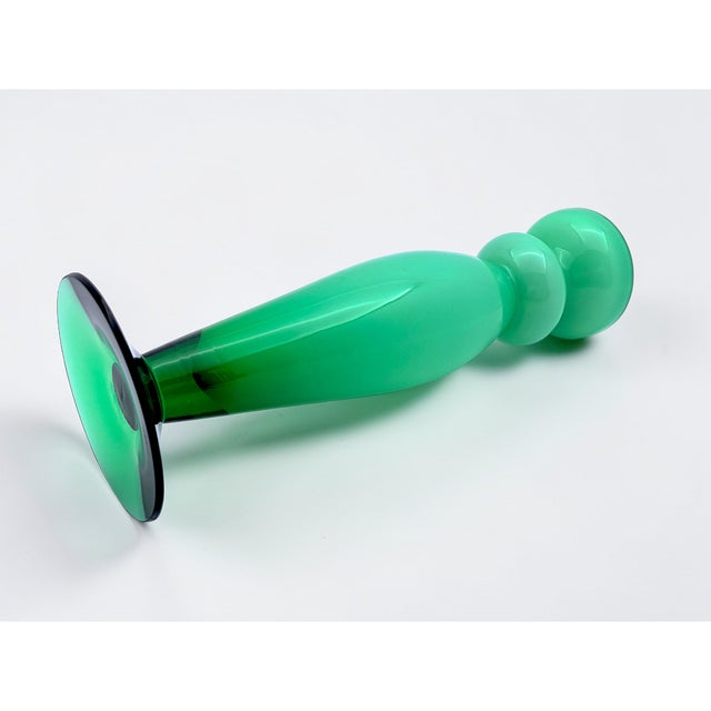 The Orrefors glass vase is a collector's item by designer Helen Krantz. It features an opaline green exterior and a white...