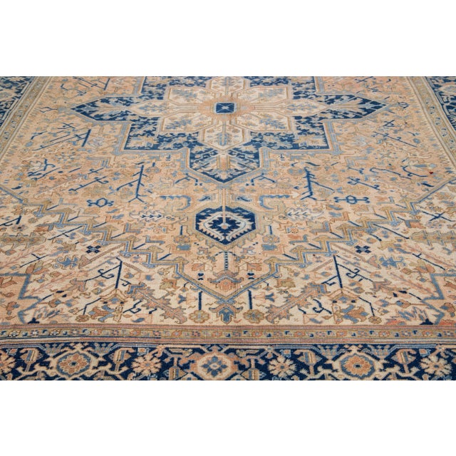 The vintage Heriz rug's hand knotted wool and remarkable medallion design exude Classic elegance and sophistication. The...