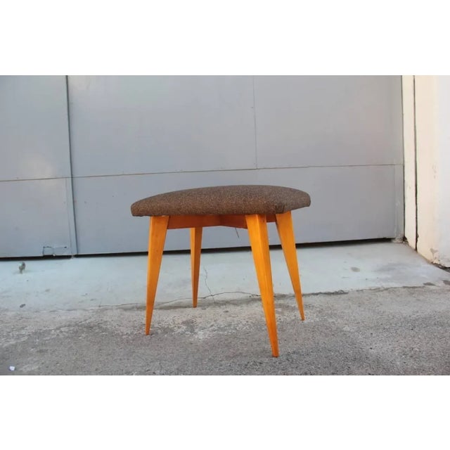 This Mid-century Italian elm stool has a geometric shape and is upholstered with wool.