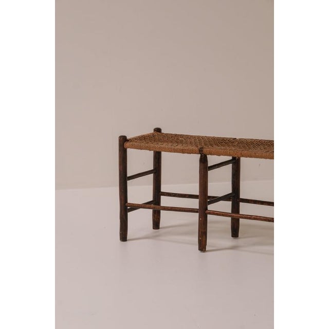 Charming French bench dating from around the 1950s, constructed with a dark-stained wooden frame and a handwoven natural...