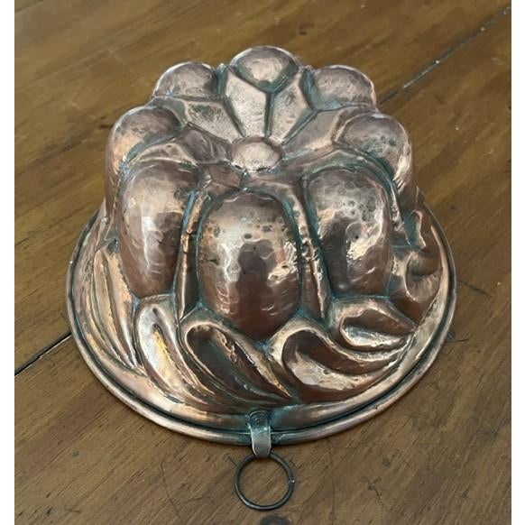 Hand hammered European antique tin lined copper pudding mold. The mold is round with rolled edges. It measures 8.5" round...