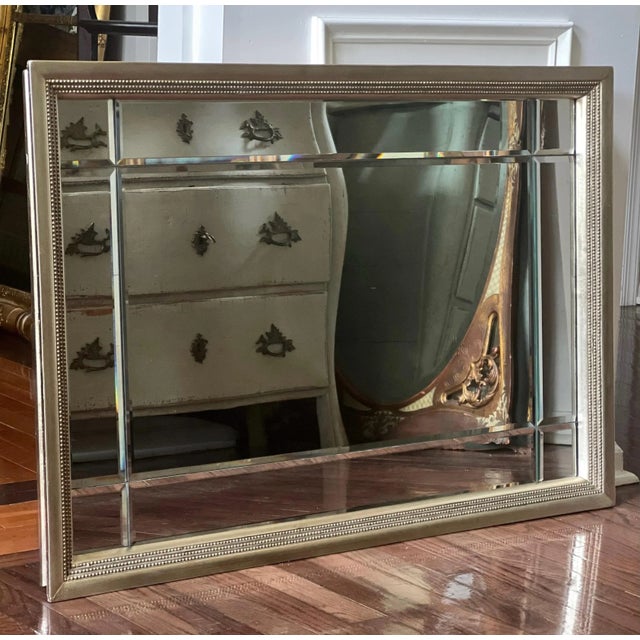A classically styled, high quality mirror with nine individually beveled panels and a soft gold gilt wood frame. It is...