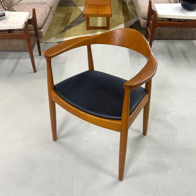 A sculptural mid-century armchair closely following Hans Wegner's celebrated 1949 Round Chair design. The curved crest...