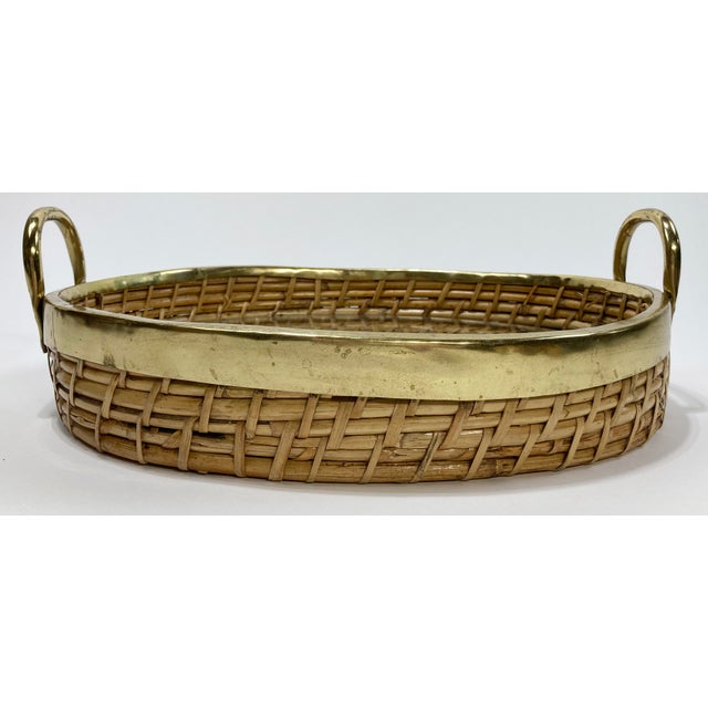 Vintage Gabriella Crespi style coiled rattan and brass tray. Features thick brass rim and handles with inset glass. A...