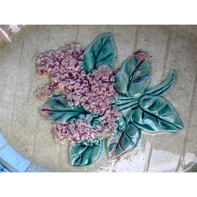 An old majolica trinket tray depicting a pink lilac. Made in England. It is aging nicely.