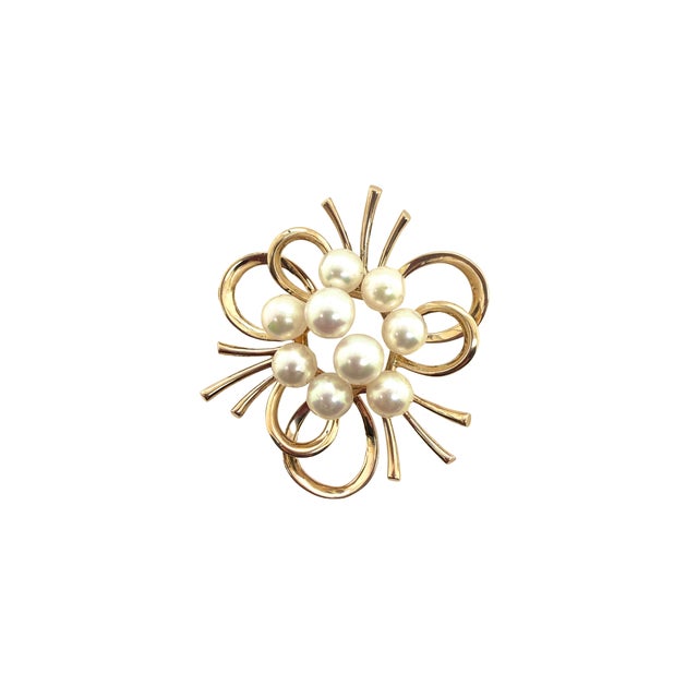 A fine 14K Gold Mikimoto pearl brooh, Circa 1960. The brooch is in the modernist style with a cluster of pearls centered...