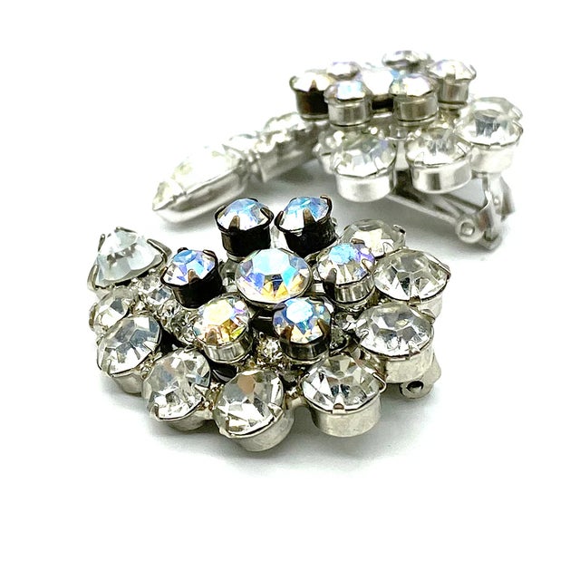 This is a pair identified D&E Juliana clear rhinestone spiral cluster clip-on earrings. All round stones and one pear...