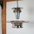 An Art Deco chromed metal and peach glass ceiling light by Petitot. Upper glass section divided by brass roundels above a...