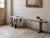 French pine bench, circa 1900, with a long narrow plank seat (219 cm) supported by two sculptural trestle legs and no...