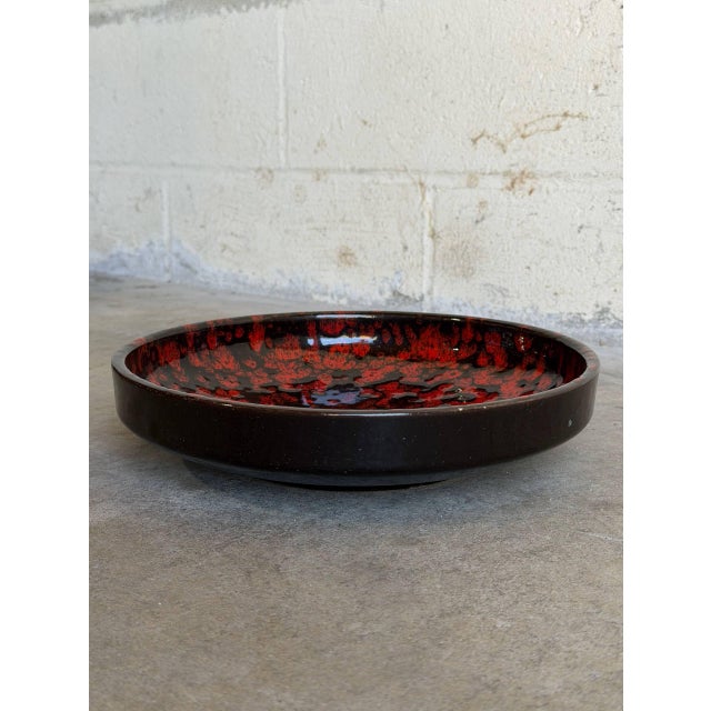 Vintage 1960s Mid-Century Modern ceramic plate features a striking, high-contrast abstract visual design. The interior...