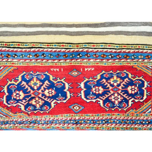 A stunning early 20th century Persian Lori horse blanket rug with ends woven with two floral medallions woven in indigo,...