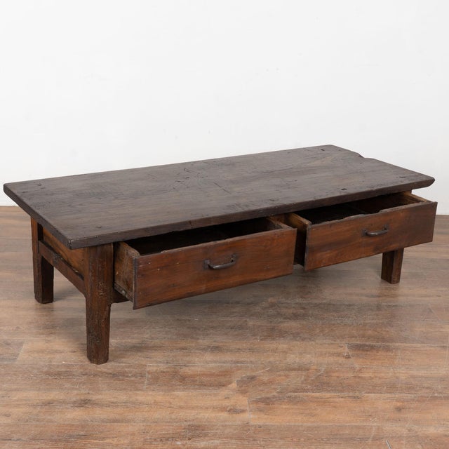 This rustic dark chestnut coffee table features two drawers with iron pulls. The extensive wear and distress give this...