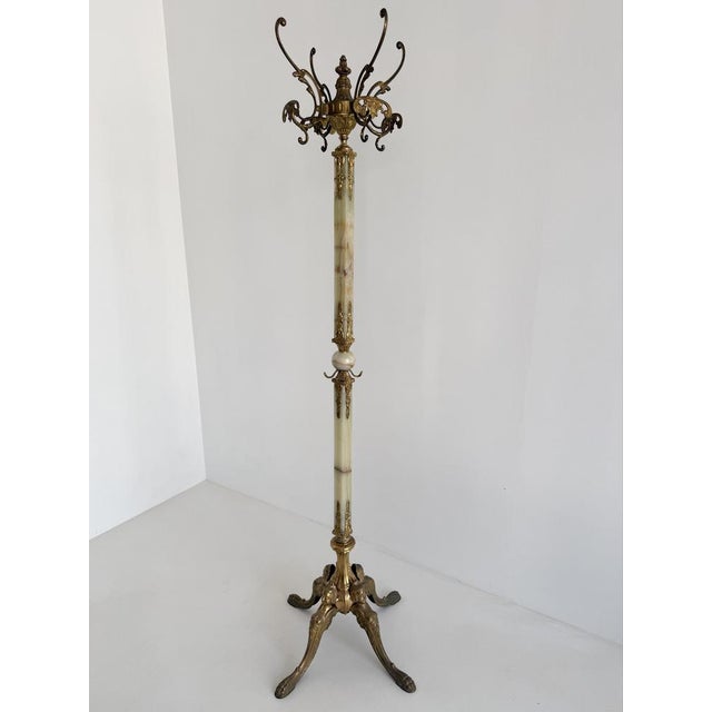 An exceptional Italian hall tree from the 1960s, crafted from richly ornamented brass and beautifully figured onyx marble....