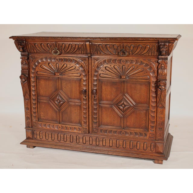 Baroque style oak sideboard, circa 1910. With a rectangular top with carved front and side edges, the frieze with two...