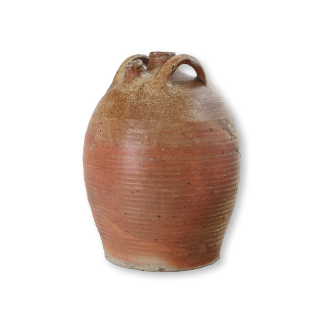 Late 19th century French terracotta olive oil jug with classic rustic form, featuring two loop handles and partial cream...