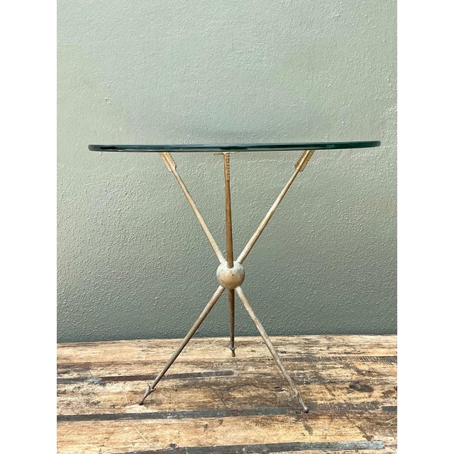 This vintage brass and glass tripod table is a striking example of mid-20th-century design, blending sculptural elegance...