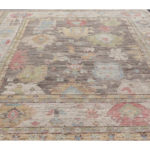 Measures: 12'5 x 16'9 Large Floral Designed Modern Oushak on a Brown-Gray Field and Cream Border. Keivan Woven Arts rug /...