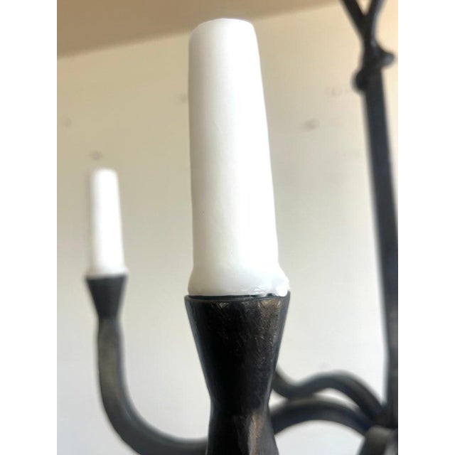 This six light chandelier has a minimalist and elegant design, crafted from wrought iron. It features six arms, extending...
