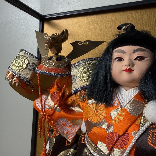 This powerful Japanese warrior figure is presented in a glass display case with a black lacquered wooden frame and an...