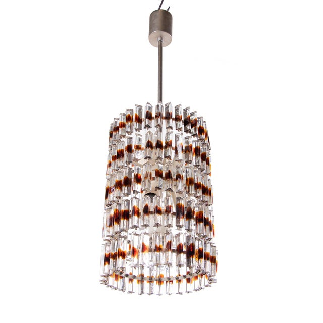 A magnificent five-tier chandelier composed of clear murano glass "triedi" prisms with amber spots, fixed on a white...