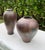A striking pair of vintage raku pottery vessels featuring complementary forms and richly variegated metallic glazes. The...