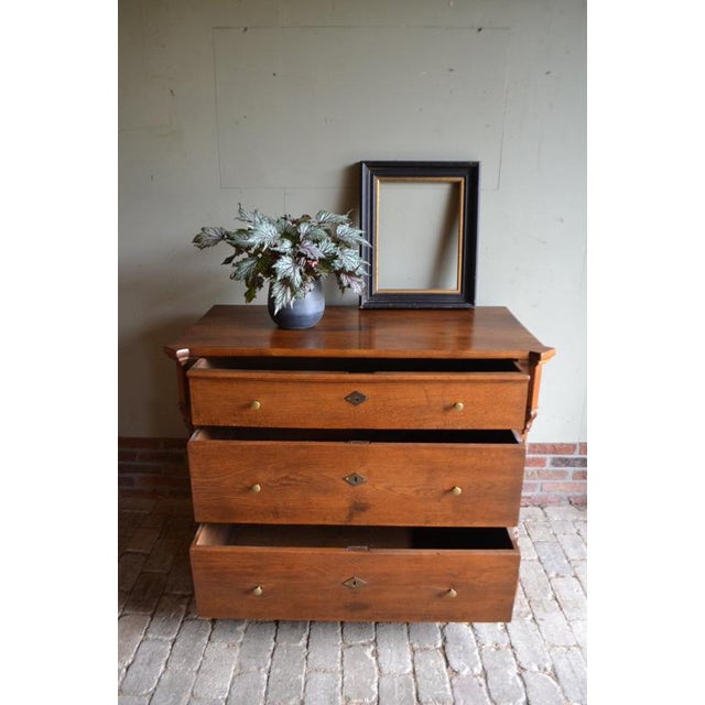 of a 19th-century German oak chest of drawers. The height is 90 cm. The width is 117 cm. The depth is 58 cm. with three...