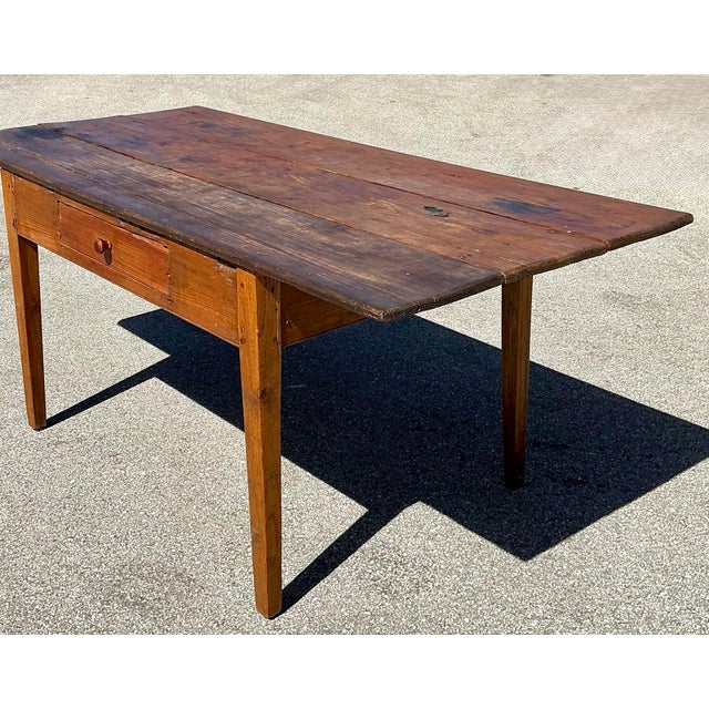 This charming antique farm table captures the soulful simplicity of early American folk design. Hand-crafted from solid...