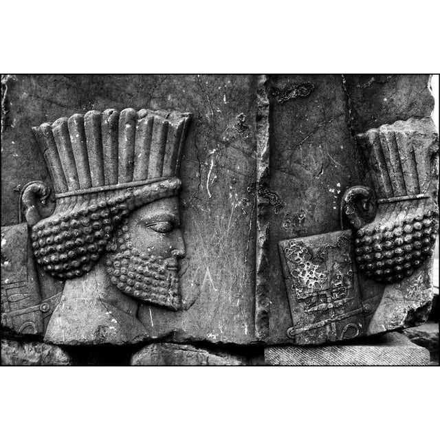 This black and white fine art photograph captures a weathered stone relief at persepolis, the ancient ceremonial capital...