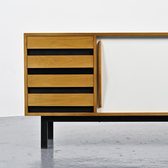 Cansado sideboard with an ash veneer body, opening with two sliding doors covered in black and white laminate and four...
