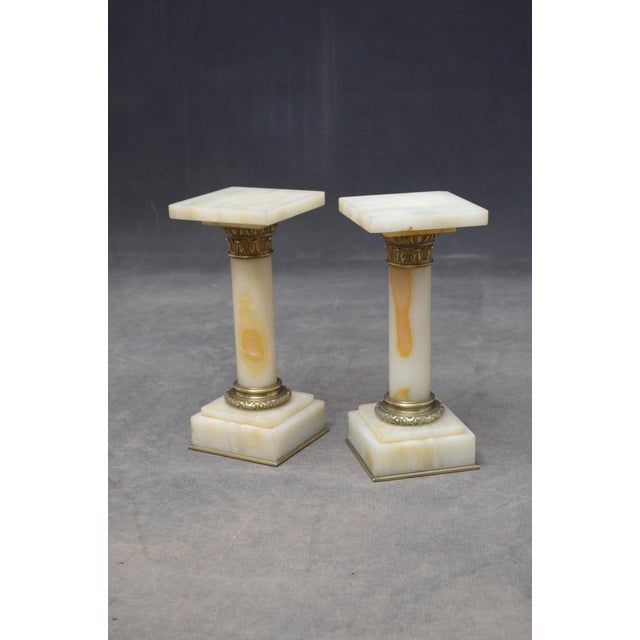 A rare pair of antique marble columns in white veined marble, each having a square platform top (one with small chip to...