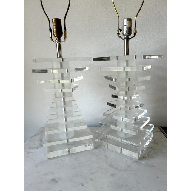 These vintage modernist stacked lucite lamps, reminiscent of Karl Springer's style and attributed to Bauer Lighting,...