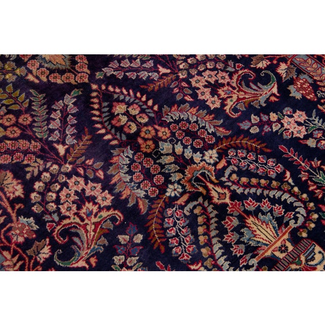 Beautiful Persian Kashan hand-knotted wool rug with a navy blue field. This piece has a red frame and multi-color accent...