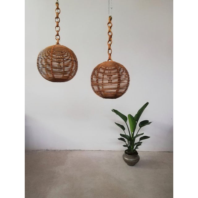 Pair of spherical chandeliers dating back to the 70s, made with thin wrapped jungle strips. The structure was restored and...
