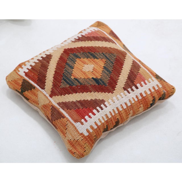 A one-of-a-kind handwoven Afghan wool kilim accent pillow featuring concentric diamond medallion with a sawtooth border....
