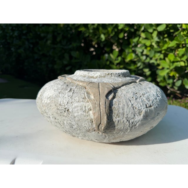 A striking vintage studio pottery vessel featuring a beautifully textured surface and weathered limestone-toned finish....