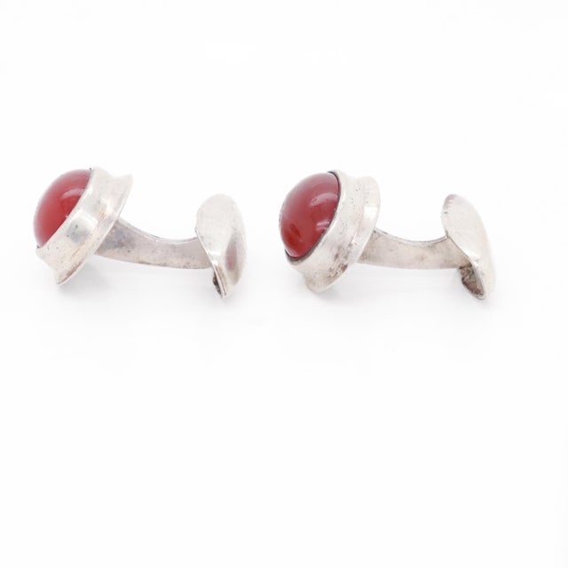 A fine pair of Swedish Mid-Century cufflinks. In 830 fine silver. Each bezel-set with oval carnelian cabochons in a high...