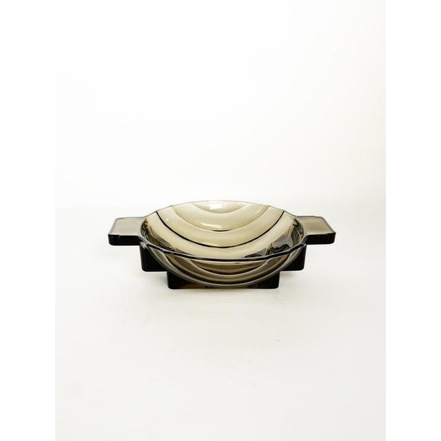 Elegant French catchall dating from the 1940s, crafted from thick smoky-tinted molded glass. The piece features a...